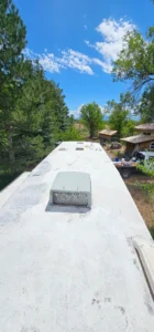 A white roof on a trailer under a clear blue sky, showcasing a bright and sunny day.