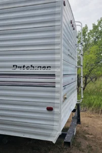 A white trailer featuring a prominent black stripe along its side.